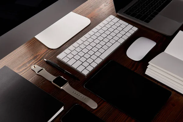 Close-up shot of modern workplace with various devices on wooden table — Stock Photo