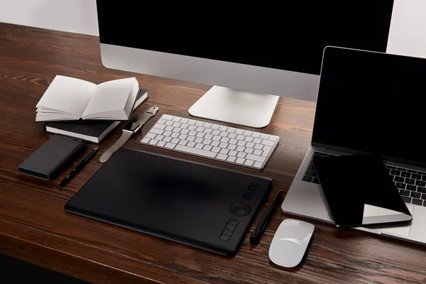 Diseño gráfico moderno lugar de trabajo con diferentes dispositivos en la mesa de madera - foto de stock