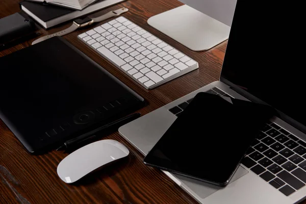 Plan rapproché du lieu de travail du concepteur avec divers gadgets sur une table en bois — Photo de stock