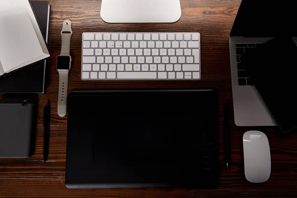 Top view of modern cg artist workplace with various gadgets on wooden table — Stock Photo