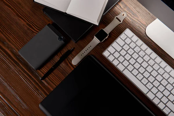 Vista superior del lugar de trabajo de diseño moderno con varios gadgets en la mesa de madera - foto de stock