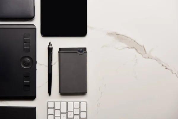 Flache Lage mit Grafik und digitalem Tablet mit tragbarer HDD und drahtloser Tastatur auf weißer Marmoroberfläche — Stockfoto