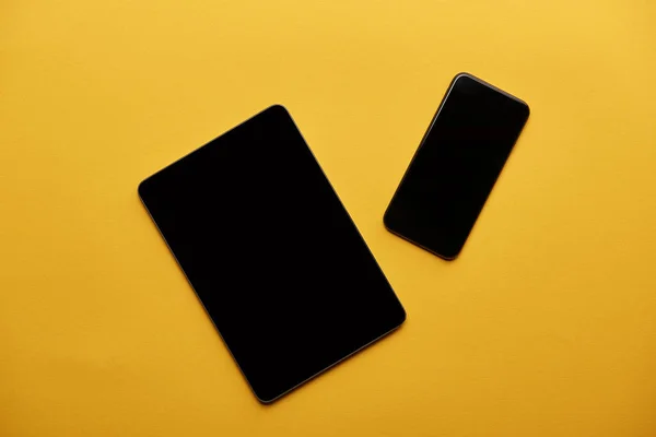 Vista superior do tablet e smartphone na superfície amarela — Fotografia de Stock