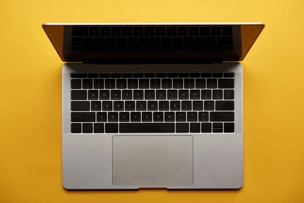 Верхний вид открытого ноутбука на желтой поверхности — стоковое фото