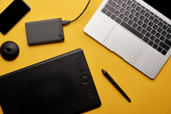 Top view of various graphic designer gadgets on yellow surface — Stock Photo