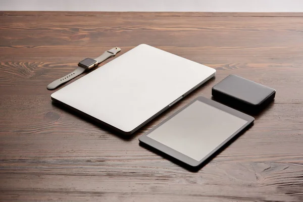 Laptop com tablet, relógio inteligente e hdd portátil na mesa de madeira — Fotografia de Stock