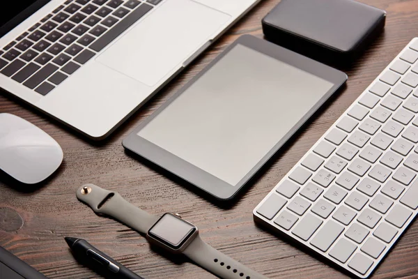 Close-up shot of different modern gadgets on wooden table — Stock Photo