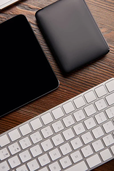 Vista dall'alto della tastiera senza fili con tablet digitale e hdd portatile su tavolo in legno — Foto stock