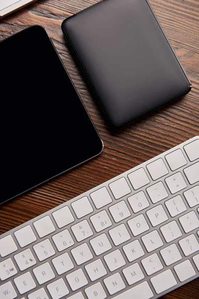 Top view of wireless keyboard with digital tablet and portable hdd on wooden table — Stock Photo