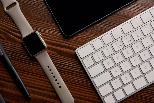 Top view of smart watch with wireless keyboard and graphics tablet on wooden table — Stock Photo
