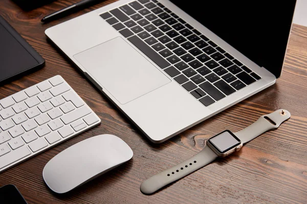 Tiro de close-up de laptop com outros vários gadgets na mesa de trabalho — Fotografia de Stock