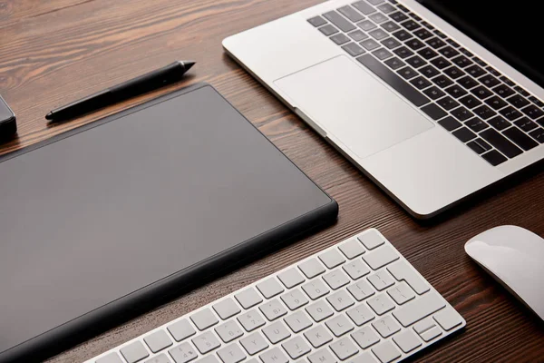 Tiro de close-up de laptop com teclado sem fio e tablet gráficos na mesa de madeira — Fotografia de Stock