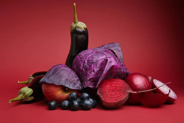 Nahaufnahme von frischem reifem Obst und Gemüse auf Rot — Stockfoto