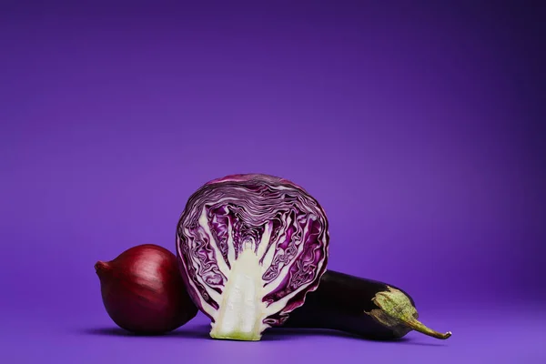 Vue rapprochée du chou tranché, de l'oignon et de l'aubergine sur fond violet — Photo de stock