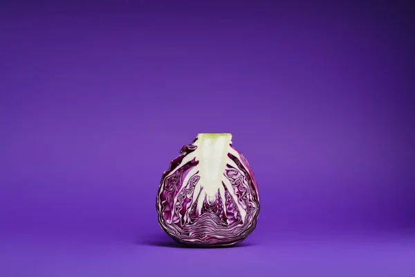 Vista de cerca de la col púrpura en rodajas orgánicas maduras frescas sobre fondo violeta - foto de stock