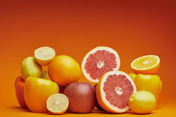 Vista de perto de citrinos maduros frescos e pimentos no fundo laranja — Fotografia de Stock