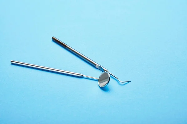 Vista de perto do espelho da boca dental e sonda na superfície azul — Fotografia de Stock