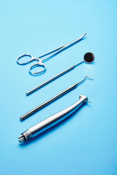 Close up view of sterile stainless dental instruments on blue background — Stock Photo