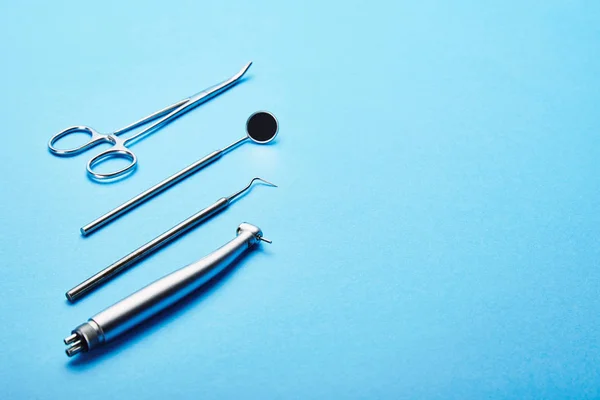 Vista ravvicinata di strumenti dentali sterili in acciaio inox su sfondo blu — Foto stock