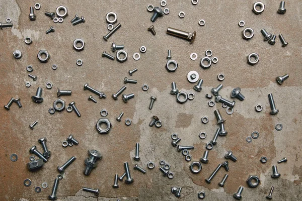 Top view of screws and bolts scattered on the background of old  surface — Stock Photo