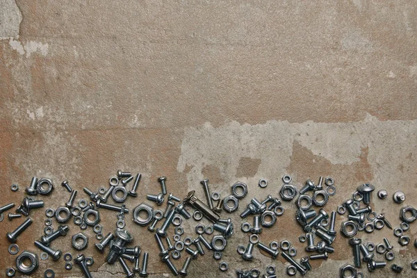 Top view of screws and bolts arranged on the background of old  surface — Stock Photo