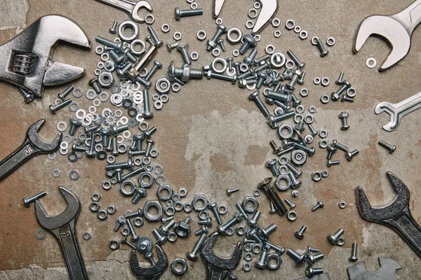 Top view of screws, bolts and wrenches arranged on the background of old  surface — Stock Photo