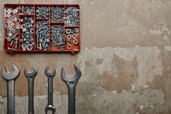 Llave plana con juego de llaves herramientas y caja de tornillos en el fondo de la superficie vieja — Stock Photo