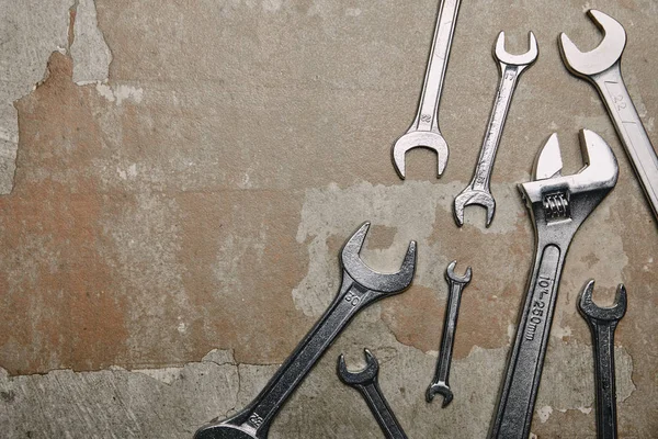 Top view of different wrenches and one monkey wrench on the background of old  surface — Stock Photo