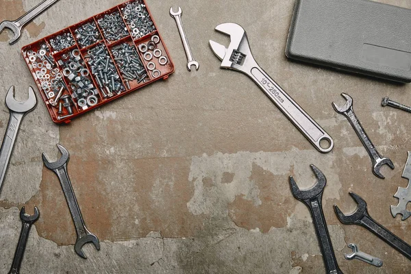 Vista superior del conjunto de herramientas de carpintería y caja con tornillos en la superficie vieja - foto de stock