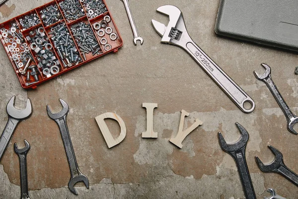 Pose plate avec signe bricolage et ensemble d'outils de menuiserie sur la vieille surface — Photo de stock