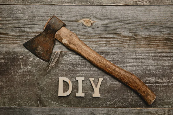 Top view of vintage rusty axe and duy sign on woodem background — Stock Photo