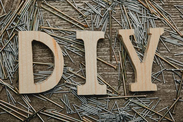 Top view of wooden diy sign and various nails tools on wooden table — Stock Photo