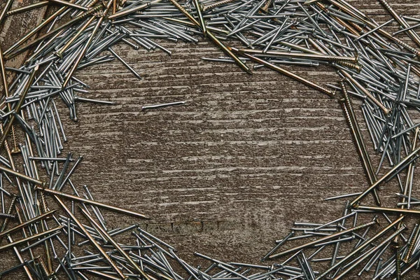 Top view of cooper and silver-colored nails arranged on wooden table — Stock Photo