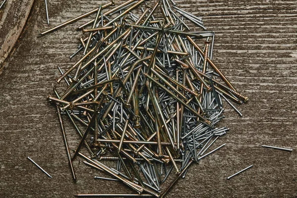 Vue du dessus du tonnelier et des clous argentés sur une table en bois sombre — Photo de stock