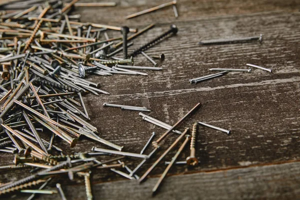 Close up of cooper and silver-colored nails on dark wooden table — Stock Photo