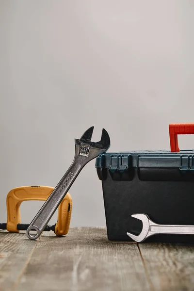 Close up of various tools on wooden table on grey background — Stock Photo