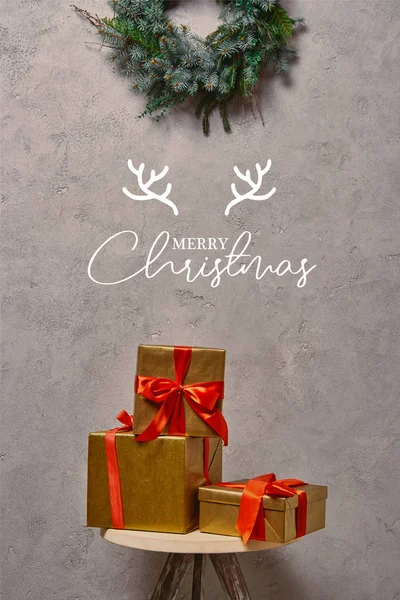 Золоті різдвяні подарункові коробки на стільці під ялинковим вінком в кімнаті з 