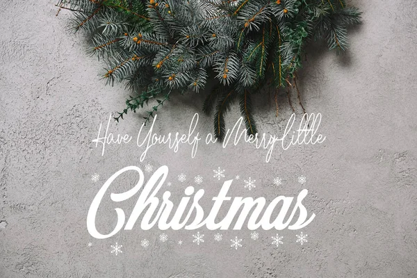 Cropped image of fir wreath for Christmas decoration hanging on grey wall with 