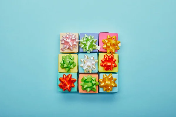 Top view of colorful gifts with bows on blue background — Stock Photo