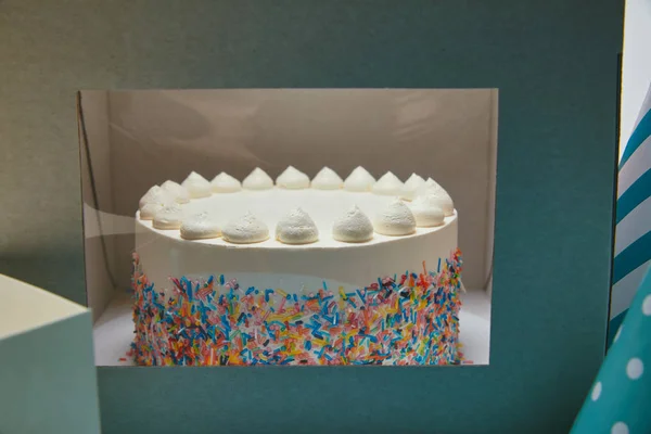 Leckerer Kuchen mit Baiser und Zuckerstreusel im Karton — Stockfoto