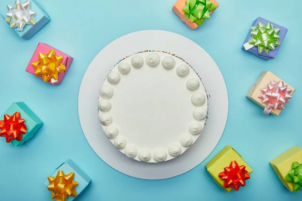 Draufsicht auf köstlichen Kuchen und Geschenke auf blauem Hintergrund — Stockfoto