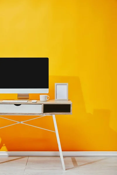 Computer, Fotorahmen und Kaffeetasse am Holztisch — Stockfoto