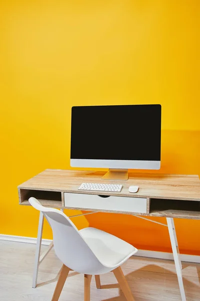Ordenador con pantalla en blanco y teclado en mesa de madera - foto de stock