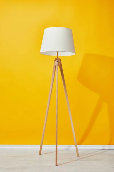 Lampada da terra minimalista vicino alla parete gialla brillante — Foto stock