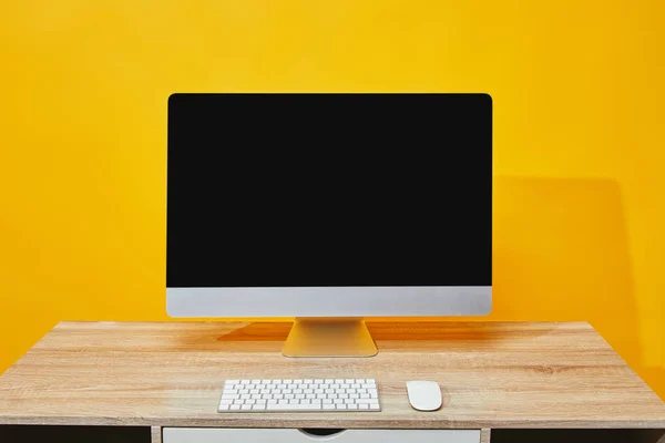 Workspace with computer,keyboard and mouse at wooden table on yellow — Stock Photo