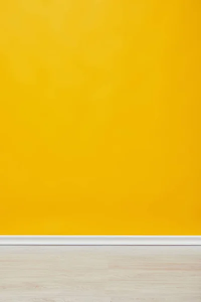 Яскрава порожня жовта стіна з дерев'яною підлогою — стокове фото
