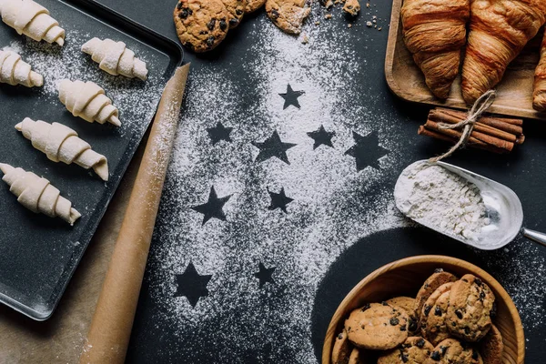 Vue du dessus du plateau avec pâte pour croissants sur la surface couverte de farine avec des symboles d'étoiles — Photo de stock