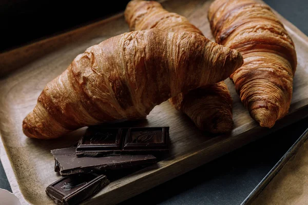 Vista de perto de chocolate e croissants na bandeja de madeira — Fotografia de Stock