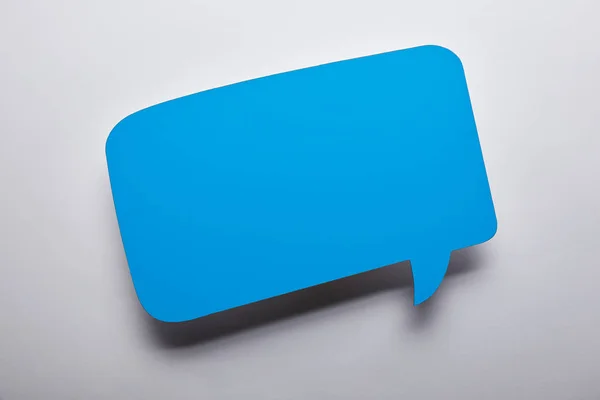 Top view of empty blue speech bubble on grey background — Stock Photo