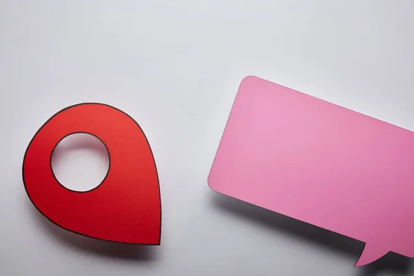 Top view of empty pink speech bubble and red geo pin on grey background — Stock Photo